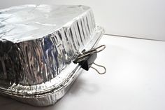 a piece of tin foil sitting on top of a white table next to a pair of scissors