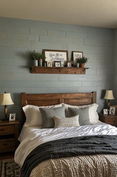 a bed with pillows and blankets in a bedroom next to two wooden shelves on the wall