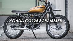 the honda cg135 scramble motorcycle is parked in front of a building