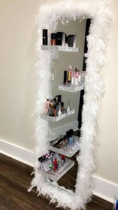 a mirror that is sitting on top of a shelf filled with makeup and other items