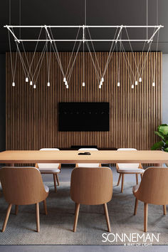 a dining room table with chairs and a flat screen tv mounted on the wall behind it