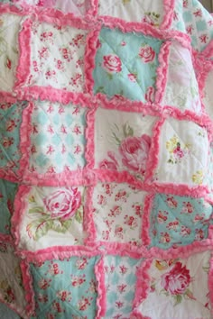 a pink and blue quilt with flowers on it