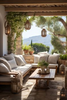 an outdoor living area with couches, tables and potted plants