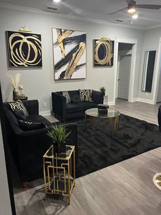 a living room filled with black couches and gold accents