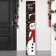 a christmas door hanger with a snowman standing next to it and garlands on the wall