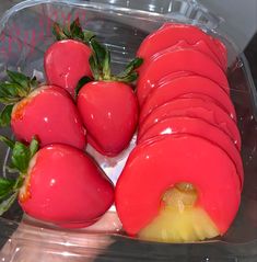 a plastic container filled with sliced up tomatoes and green leaves on top of each other