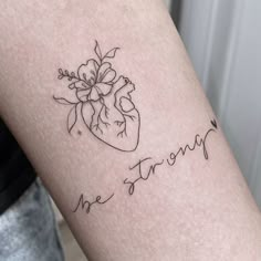 a tattoo on the arm of a woman with a heart and flowers in her hand