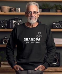 an older man wearing a black sweatshirt with the words grandpa printed on it in white