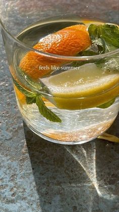 an orange and lemon drink in a glass on a table with the caption reads, feels like summer