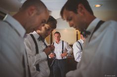 a group of men standing next to each other wearing suspenders and ties on their shirts