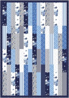 a blue and white patchwork quilt with flowers on the front, in different shades