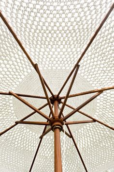 the inside of an umbrella is made from wood and white mesh covering it's top