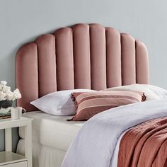 a pink headboard on a bed in a bedroom