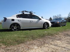 two cars parked in the grass with their skis on top of one car's roof rack