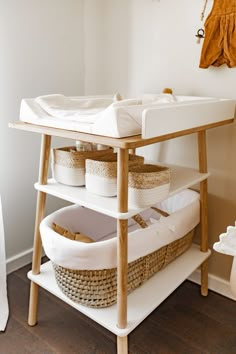 a baby changing table with baskets on it