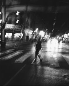 a person walking across a street at night