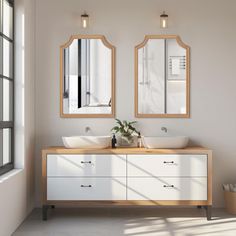 a bathroom with two sinks and mirrors on the wall next to a window in front of it