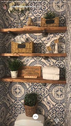 the bathroom is decorated in blue and white tile with wooden shelves above it, along with potted plants