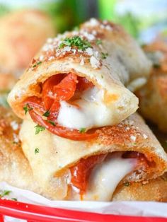 some food is stacked on top of each other in a red basket with white paper