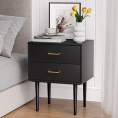 a nightstand with two drawers and some yellow flowers