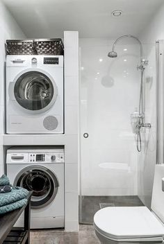 a washer and dryer in a small bathroom with white walls, tile flooring