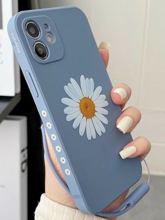 a woman holding up her phone case with a flower on it