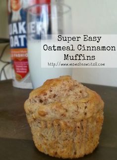 a muffin sitting on top of a table next to a glass of milk