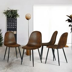 a group of chairs sitting next to each other in a room with a potted plant