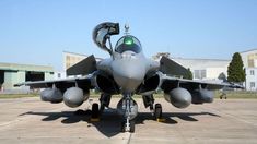 a fighter jet sitting on top of an airport tarmac