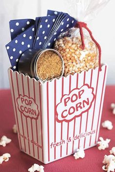 the popcorn box is filled with popcorn and has a blue polka dot bow on it