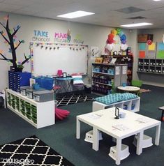 a classroom with tables, chairs and desks in the center is decorated with colorful decorations