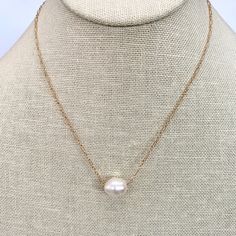 This elegant necklace showcases the timeless beauty of a single pearl delicately dangling from a dainty gold chain. The simplicity of the design highlights the natural allure of the pearl, creating a graceful and sophisticated piece. The necklace measures 16 inches in length, offering a classic and flattering fit around the neckline. Additionally, it can be adjusted to a shorter length of 15 inches, allowing you to wear it as a choker-style necklace for a more intimate and refined look. The sing Classic Gold Charm Necklace With Pearl Drop, Minimalist Pearl Chain Necklace With Pearl Charm, Classic Pearl Charm Necklace With Pearl Pendant, Classic White Charm Necklace With Pearl Drop, Minimalist Pearl White Chain Necklace With Pearl Drop, Minimalist Pearl Drop Chain Necklace In Pearl White, Minimalist Pearl Drop Necklace With Pearl Chain, Simple Pearl Chain Necklace, Classic Pearl Charm Necklace With Pearl Drop