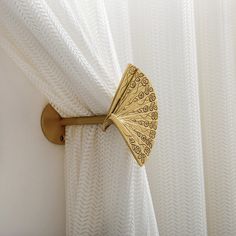 the curtain is closed and there is a decorative gold fan on it's side