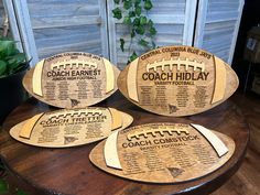 three football shaped coasters sitting on top of a wooden table