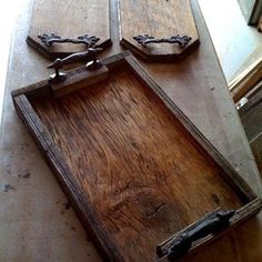 two wooden trays sitting on top of a table next to each other with metal handles