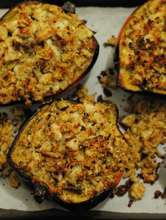 four stuffed eggplant halves are sitting on a baking sheet with some toppings