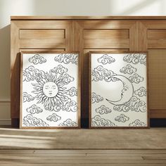 two sun and moon pictures are on display in front of a wooden cabinet with wood flooring