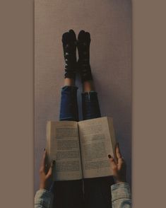 a person with their legs crossed reading a book