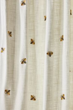 a white curtain with yellow bees on it