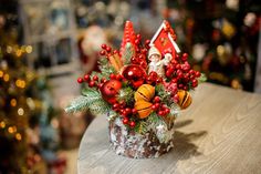 a christmas centerpiece on a table in front of a christmas tree and other decorations