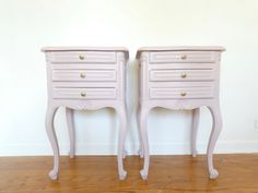 two pink nightstands sitting next to each other on top of a wooden floor