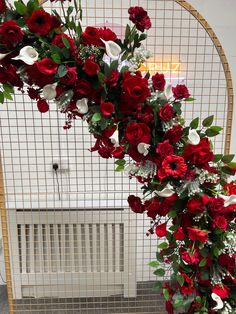 a bunch of red and white flowers are arranged in a circular arrangement on a table