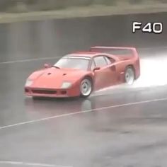 a red sports car driving down a wet track