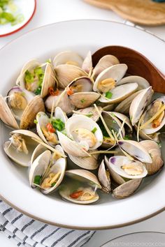 a white bowl filled with clams on top of a table