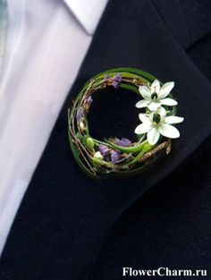 a man wearing a suit and tie with flowers in his lapel flower charm on his lapel