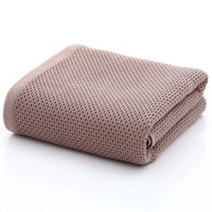 a blanket is folded on top of a white surface with a light brown color scheme