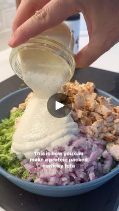 a person pouring dressing into a bowl filled with food