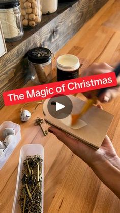 the magic of christmas is being held over a table with lots of crafting supplies