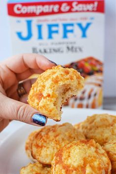 a person holding up a piece of food in front of a box of jeffy