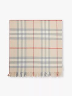 the classic check cash scarf is shown in light grey and peach, with an orange fringe